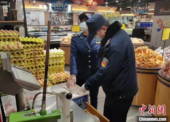 圖為疫情期間，甘肅嘉峪關(guān)市場監(jiān)管局工作人員檢查蔬菜市場?！?柴佳楠 　攝