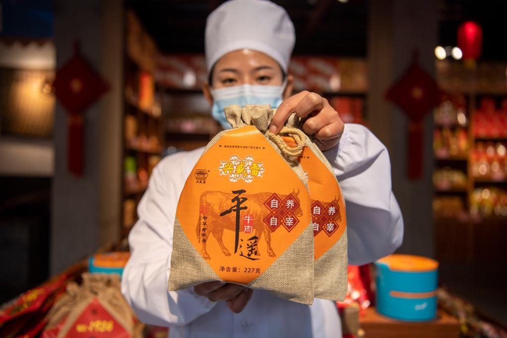 1月27日，在平遙古城南大街的一家平遙牛肉店內(nèi)，工作人員展示一款牛肉產(chǎn)品。新華社記者 楊晨光 攝