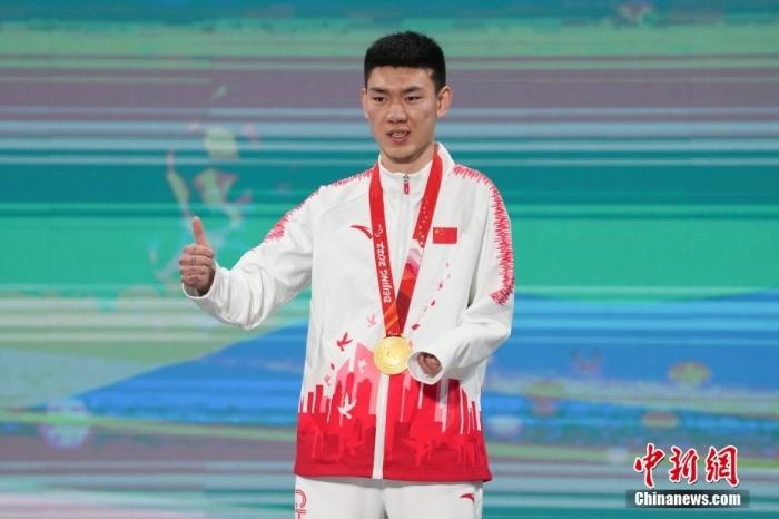 3月6日，梁景怡在延慶頒獎(jiǎng)廣場領(lǐng)獎(jiǎng)臺上豎起大拇指。當(dāng)日，在國家高山滑雪中心舉行的北京2022年冬殘奧會殘奧高山滑雪男子超級大回轉(zhuǎn)—站姿決賽中，中國選手梁景怡奪得冠軍。 <a target='_blank' href='/'>中新社</a>記者 楊華峰 攝