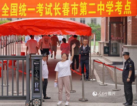 6月7日，在長春市第二中學(xué)考點，一名考生信心滿滿進(jìn)入考場，并與家長揮手致意。人民網(wǎng)記者 李洋攝
