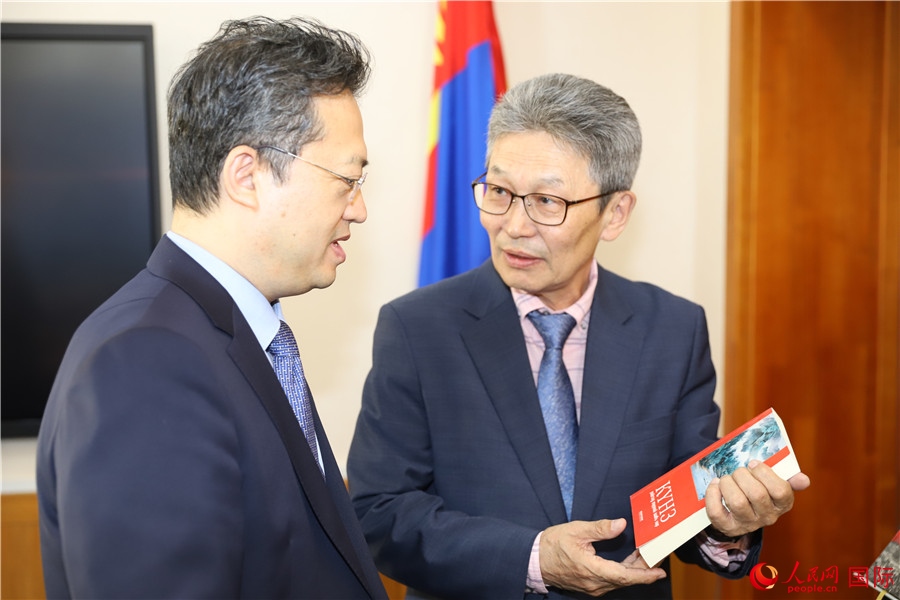 其米德策耶（右一）向李峙介紹翻譯成果。人民網(wǎng)記者 霍文攝