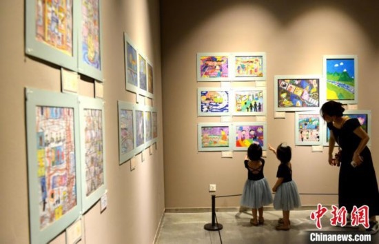 圖為家長(zhǎng)帶著孩子參觀展覽。呂明 攝