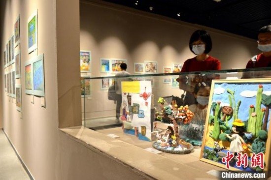 圖為家長(zhǎng)帶著孩子參觀展覽。呂明 攝