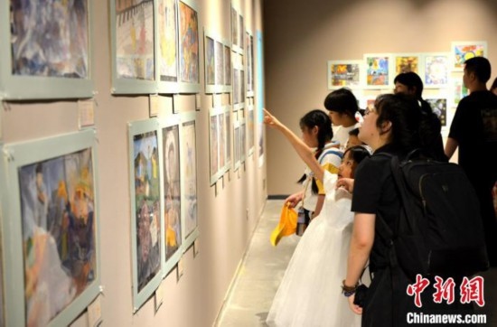 圖為家長(zhǎng)帶著孩子參觀展覽。呂明 攝