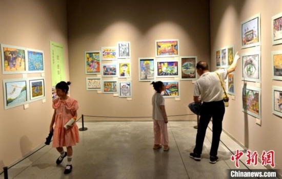 圖為家長(zhǎng)帶著孩子參觀展覽。呂明 攝