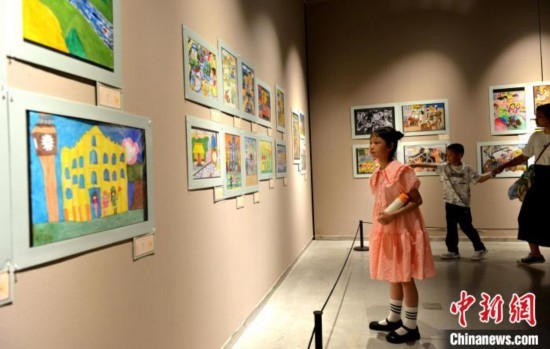 圖為家長(zhǎng)帶著孩子參觀展覽。呂明 攝