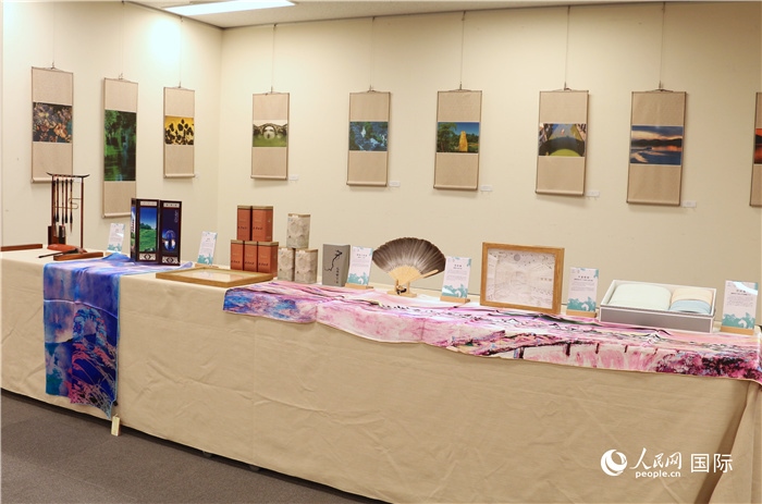 現(xiàn)場(chǎng)展出的馮學(xué)敏攝影作品與湖州市特色工藝品。（人民網(wǎng) 許可攝）