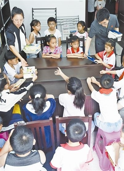  圖④：法院干警為留守兒童發(fā)放暑假讀物。