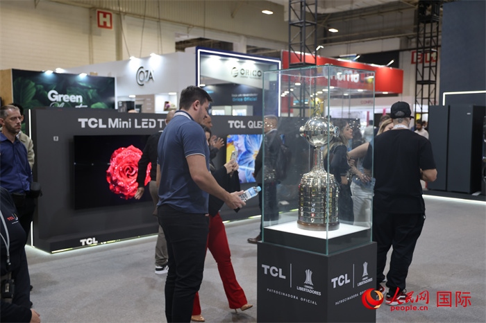 參觀者在TCL展臺前觀看南美解放者杯獎杯，據(jù)介紹，TCL是南美解放者杯（2023—2026賽季）全球官方合作伙伴。（人民網(wǎng)記者 時元皓攝）