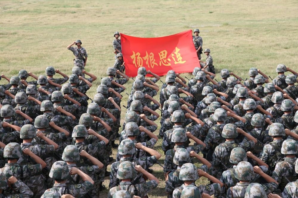 ↑“楊根思連”官兵執(zhí)行任務(wù)前向連旗宣誓（資料照片）。新華社發(fā)