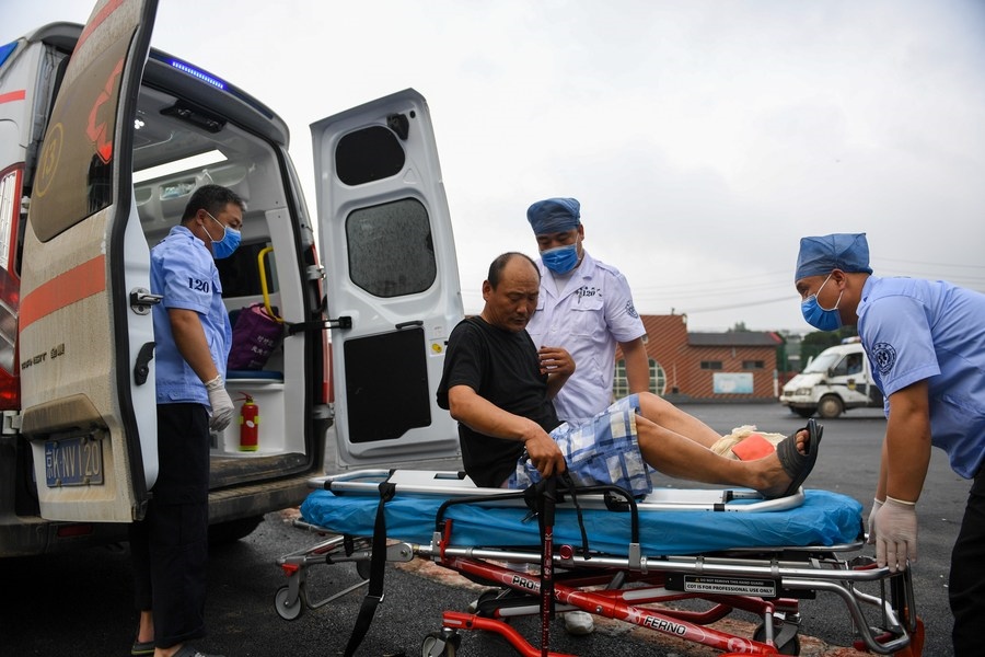 8月1日，在北京市門頭溝區(qū)妙峰山鎮(zhèn)妙峰山民族學校臨時安置點，北京急救中心工作人員在轉運一名受傷村民。新華社記者 鞠煥宗 攝