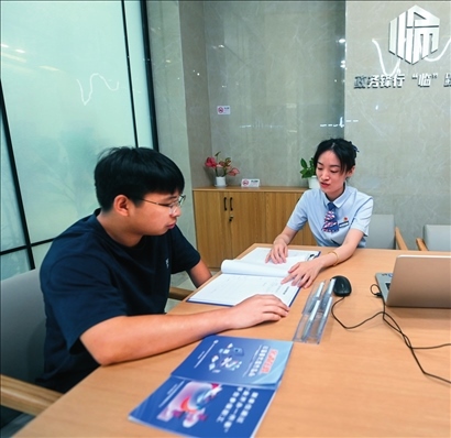 在杭州市臨安區(qū)政務(wù)服務(wù)中心的“為企服務(wù)中心”，黨員志愿者（右）解答企業(yè)主的疑問(wèn)（2023年7月7日攝）。徐昱攝/本刊