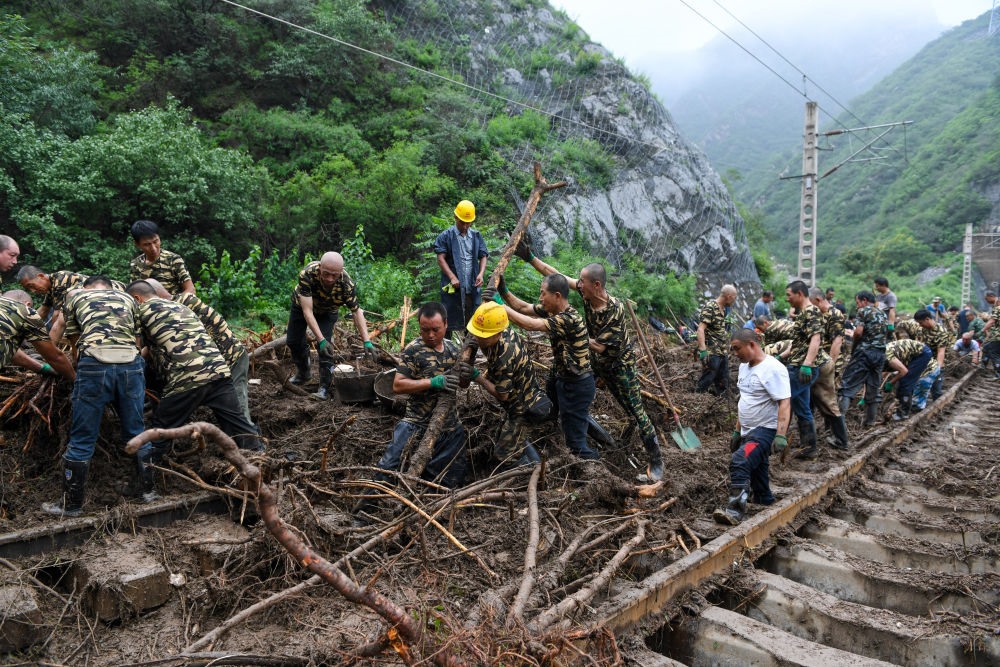 8月1日，在北京市門頭溝區(qū)水峪嘴村附近一段被阻斷的鐵路線上，中鐵六局工作人員在清理軌道上的雜物，全力恢復(fù)交通。新華社記者 鞠煥宗 攝