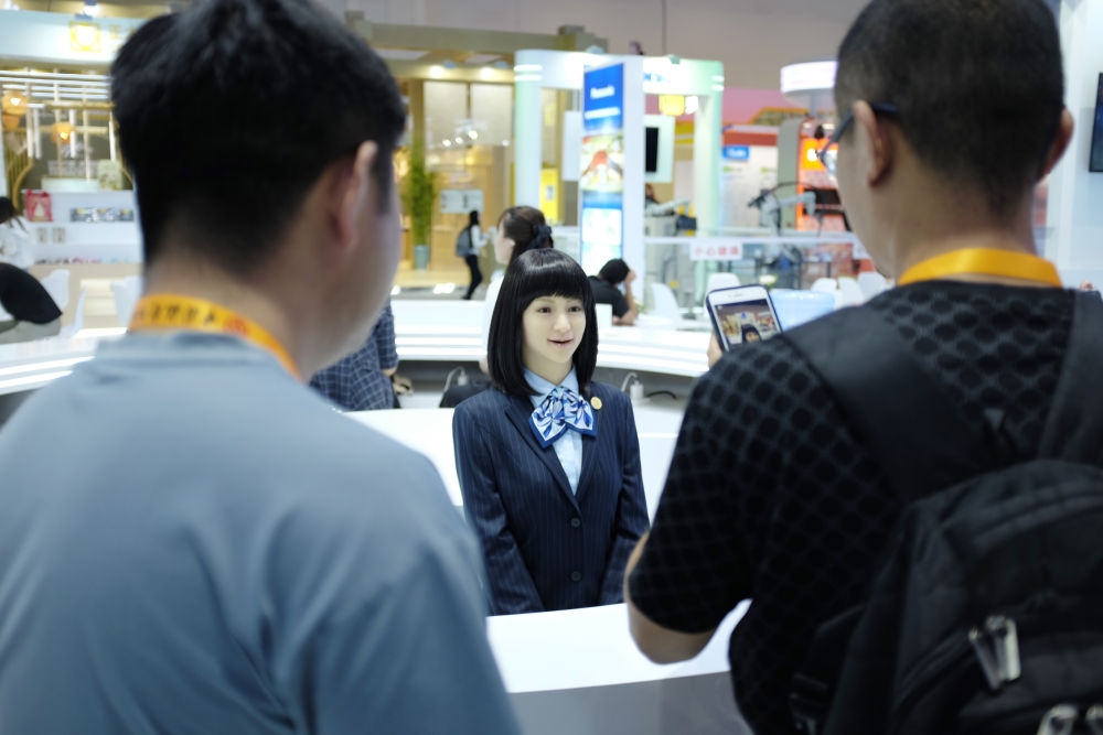 9月1日，媒體記者在國家會議中心與服務(wù)機(jī)器人互動。新華社記者 劉夢琪 攝