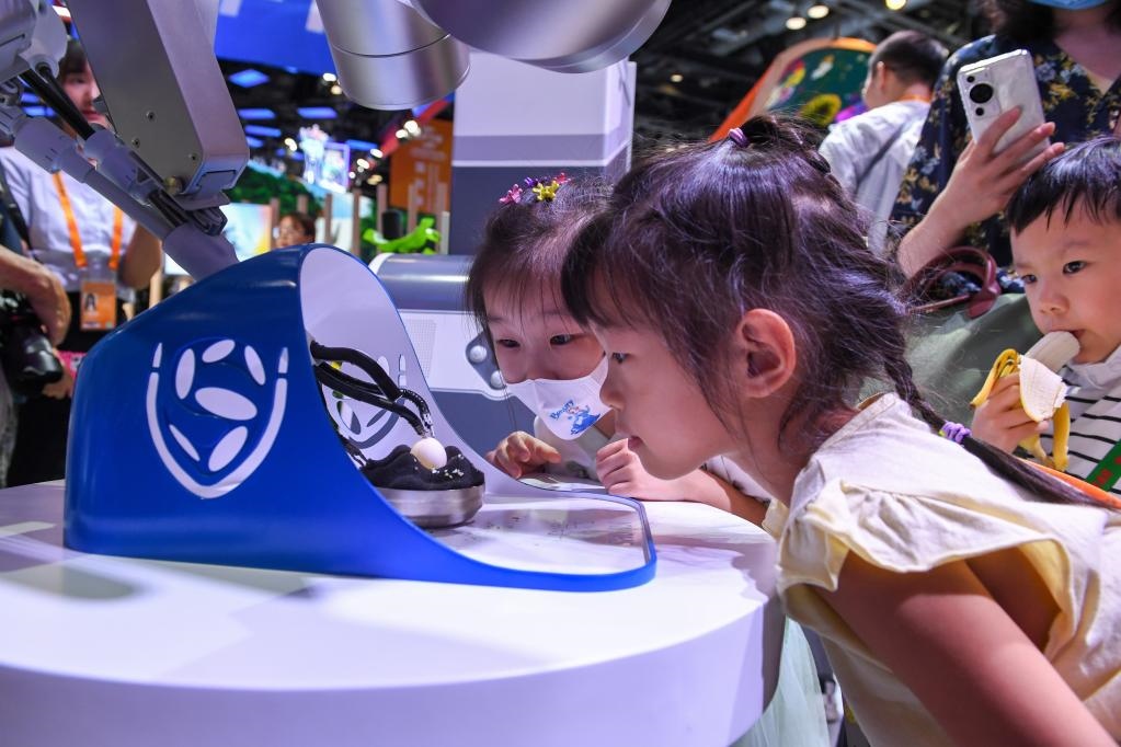 9月3日，幾名小朋友在國家會(huì)議中心觀看單孔腔鏡手術(shù)機(jī)器人展示。新華社記者 鞠煥宗 攝