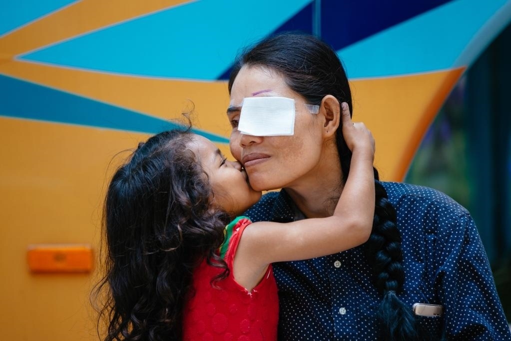 2019年3月15日，在柬埔寨磅湛省醫(yī)院，即將接受白內(nèi)障手術的患者孫美樂接受女兒的親吻祝福。在接受了中國醫(yī)療隊的白內(nèi)障義診手術后，她的視力逐步恢復，生活有了新的光明和希望。