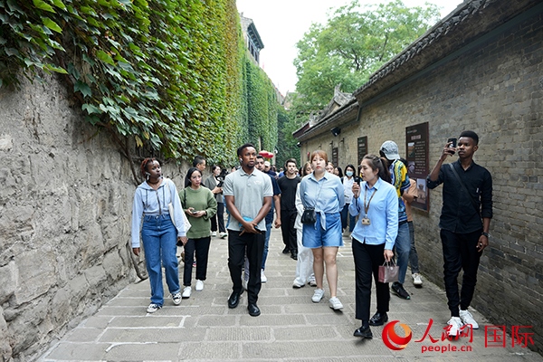 選手們認(rèn)真聆聽導(dǎo)游講解。人民網(wǎng) 盧鵬宇攝