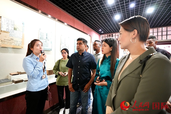 選手們認(rèn)真聆聽導(dǎo)游講解。人民網(wǎng) 盧鵬宇攝