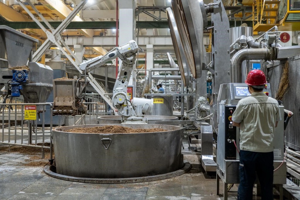 907車間里，機(jī)械臂正在撒料裝甑。嚴(yán)磊攝