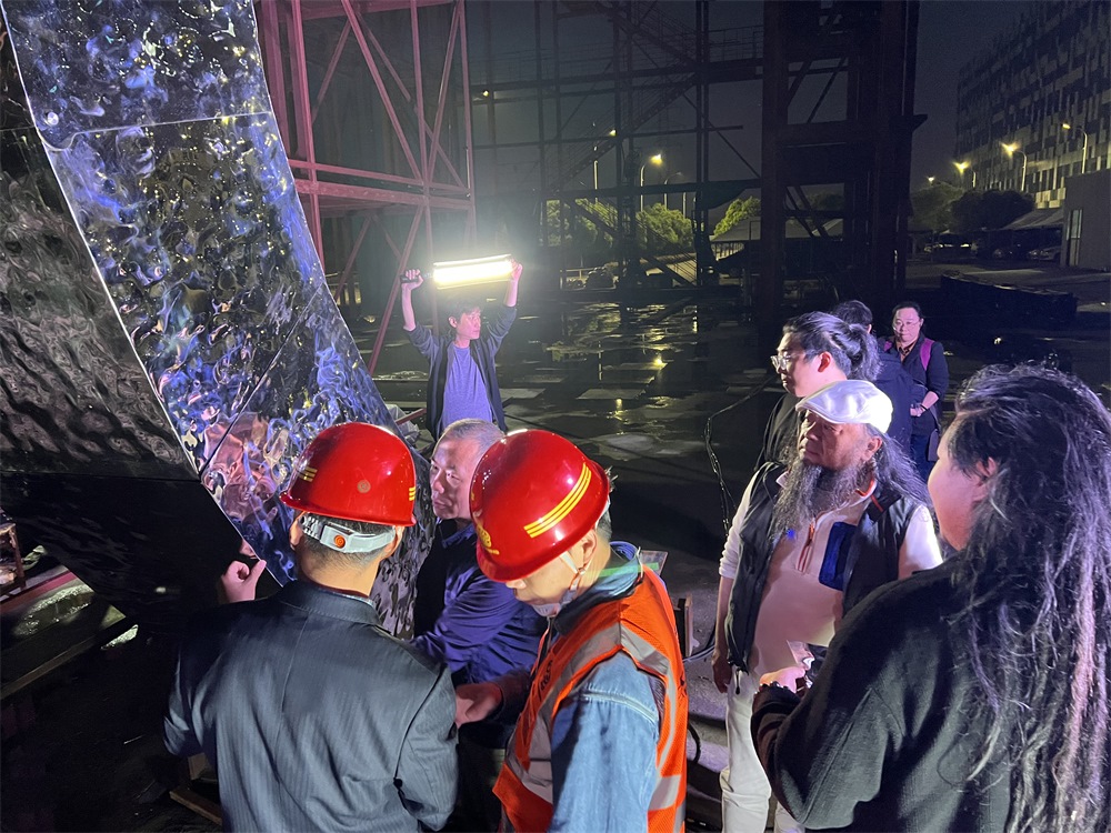 林崗（右二）和團隊查看主火炬制作進度。受訪者供圖