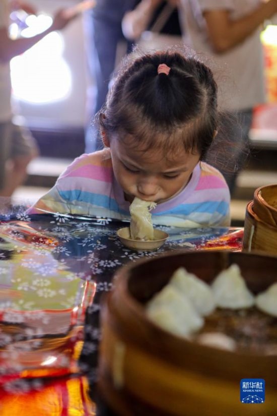 9月27日，小朋友在南翔小籠長街宴上品嘗南翔小籠。