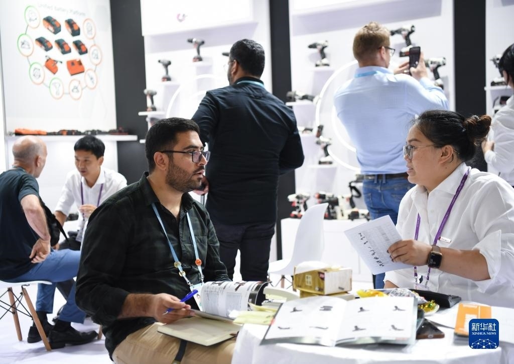 10月15日，在一家電動工具展臺，外國采購商在洽談業(yè)務。新華社記者 鄧華 攝