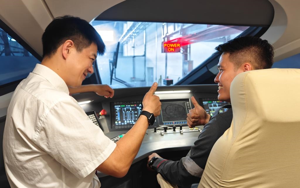 8月25日，在印度尼西亞萬(wàn)隆的雅萬(wàn)高鐵德卡魯爾動(dòng)車(chē)所內(nèi)，中國(guó)師傅穆振（左）在向印尼火車(chē)司機(jī)塞蒂亞萬(wàn)講解動(dòng)車(chē)組出庫(kù)前的上電作業(yè)。