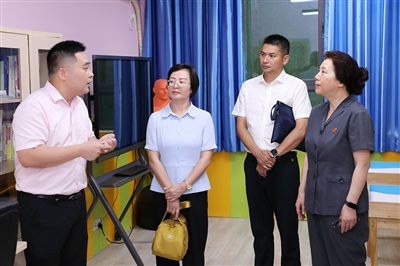 圖③：“小公民法律課堂”開講前，全國(guó)人大代表殷其龍（右二）、重慶市人大代表李自玲（左二）聽取楊家坪中學(xué)負(fù)責(zé)人關(guān)于未成年人思想教育工作情況的介紹。