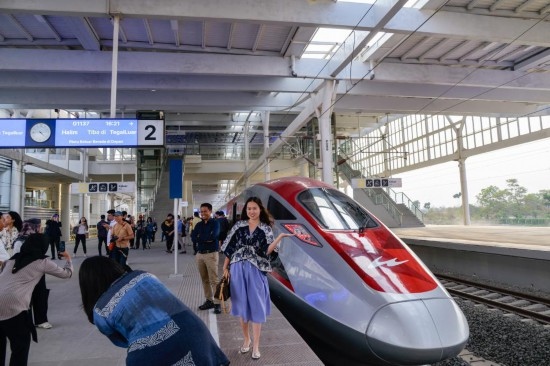  10月17日，在印度尼西亞萬隆德卡魯爾站，乘客在站臺上和雅萬高鐵高速動車組列車合影。新華社記者 徐欽 攝