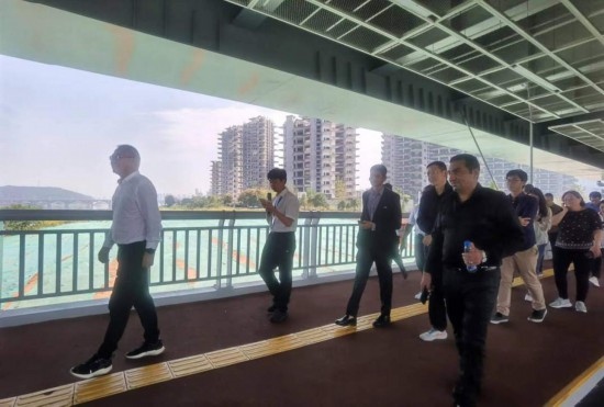 10月24日，2023“一帶一路”媒體合作論壇聯(lián)合采訪團(tuán)團(tuán)員走在清水塘大橋景觀通道上。本報(bào)記者 常雯宜攝