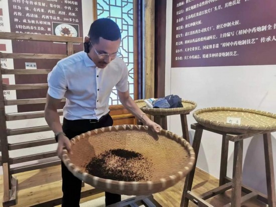 2023“一帶一路”媒體合作論壇聯(lián)合采訪團(tuán)團(tuán)員在非遺文化展示館體驗中藥炮制技藝。（本報記者 黃超攝）