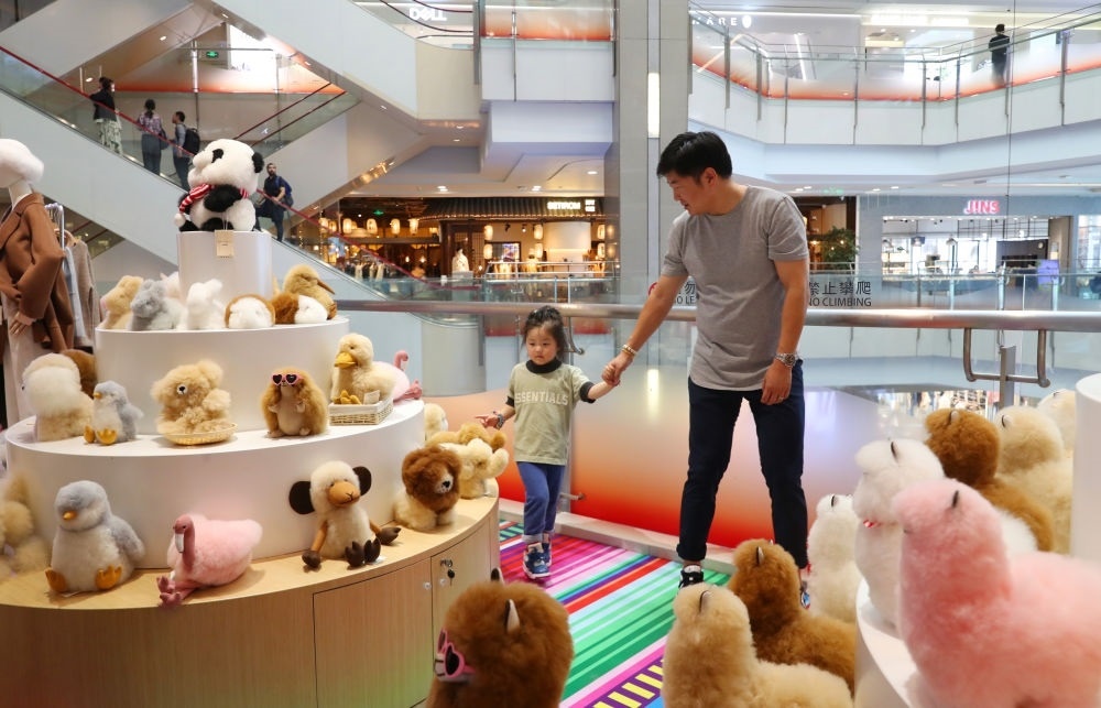 2023年11月2日，顧客在溫暖駝品牌專柜內(nèi)選購。連續(xù)六年參加進博會的秘魯羊駝制品品牌溫暖駝在上海市中心商場開設了專柜。新華社記者 方喆 攝