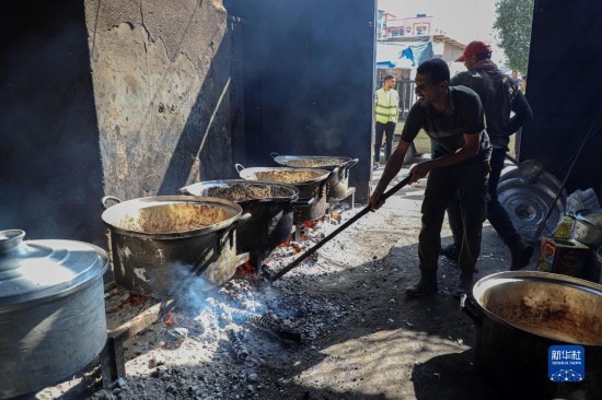11月3日，在加沙地帶南部城市拉法，人們?cè)诿簹庵袛嗪笥貌窕鹱鲲?。新華社發(fā)（里澤克·阿卜杜勒賈瓦德攝）
