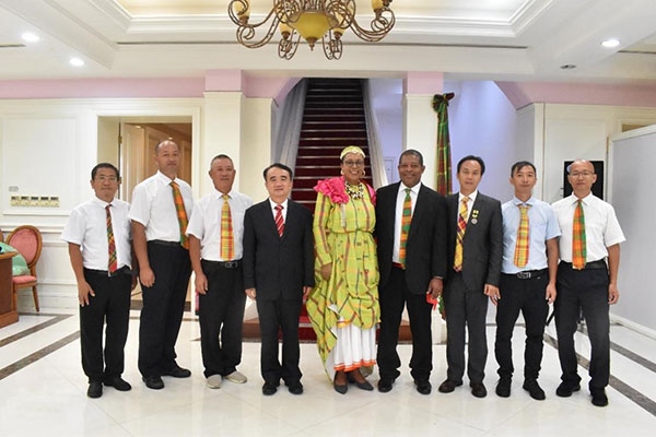 多米尼克總統(tǒng)伯頓和駐多米尼克大使林先江與中國(guó)農(nóng)業(yè)技術(shù)專(zhuān)家組合影。中國(guó)駐多米尼克大使館供圖