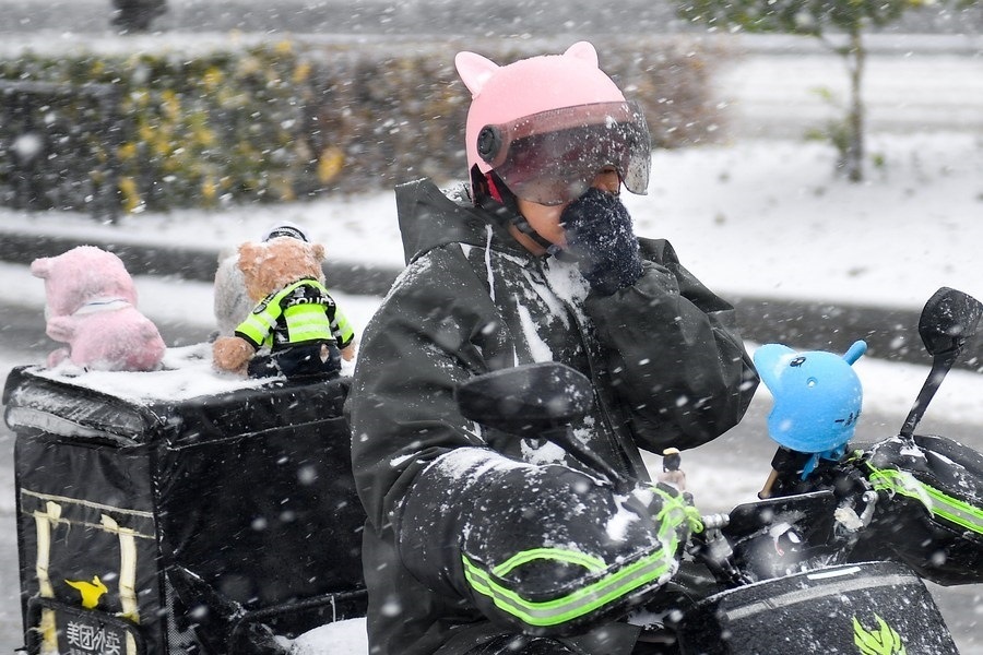 11月6日，在長春市街頭，一名外賣員在雪中騎行。新華社記者 許暢 攝