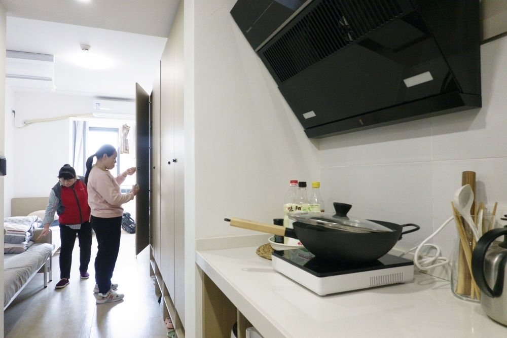 住戶在閔行區(qū)新時代城市建設(shè)者管理者之家收拾房間。