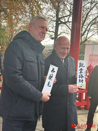 柏林市長(zhǎng)韋格納（右）、動(dòng)物園監(jiān)事會(huì)主席布魯克曼（左）手持中國(guó)文化中心工作人員現(xiàn)場(chǎng)手書(shū)的中文名字。人民網(wǎng)記者 徐馨攝