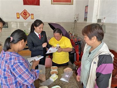  圖⑤：龍圩區(qū)法院法官到群眾家中開展法治宣傳。資料圖片