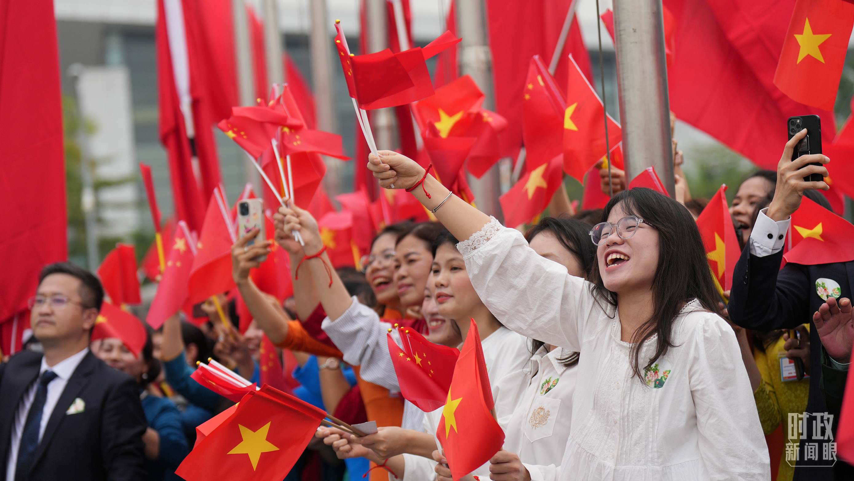 △人們揮舞兩國旗幟歡迎習(xí)近平訪越。（總臺國廣記者李晉拍攝）