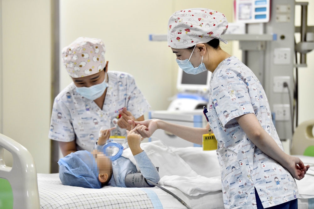 在山東省棗莊市婦幼保健院兒童ICU病房，醫(yī)護(hù)人員為完成靶向治療藥物諾西那生鈉的4歲脊髓性肌萎縮癥患兒加油鼓勁（2022年1月1日攝）。諾西那生鈉注射液是我國(guó)首個(gè)獲批治療脊髓性肌萎縮癥的進(jìn)口藥物，2019年進(jìn)入中國(guó)市場(chǎng)時(shí)，每針價(jià)格近70萬(wàn)元。在2021年國(guó)家醫(yī)保目錄藥品談判中，以3.3萬(wàn)元每針的價(jià)格進(jìn)入新版醫(yī)保藥品目錄。新華社記者 郭緒雷 攝