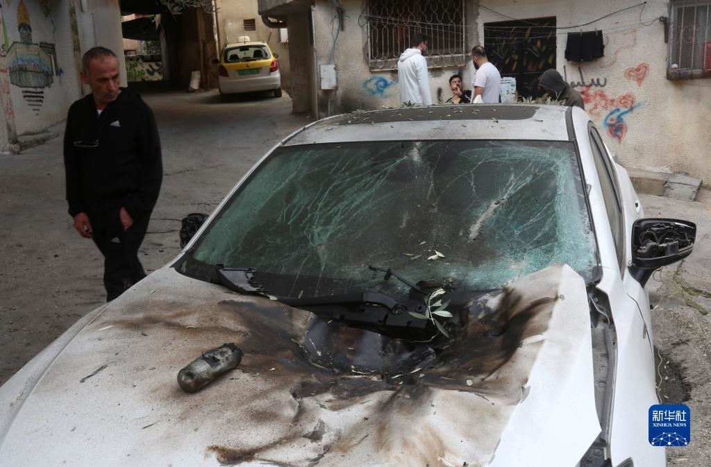 12月17日，在約旦河西岸城市圖勒凱爾姆附近的一處難民營，人們查看在沖突中損毀的車輛。新華社發(fā)（尼達爾·艾仕塔耶攝）