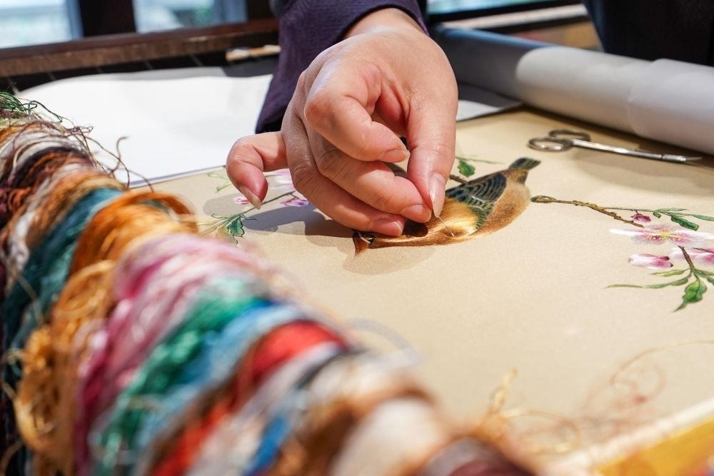 △2023年7月6日，盧建英在江蘇蘇州平江路的工作室內(nèi)刺繡。