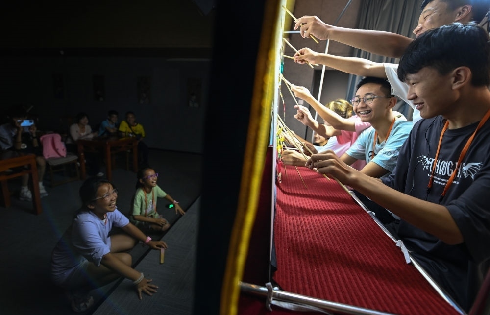 2023年8月8日，進(jìn)行暑期研學(xué)的學(xué)生在位于陜西省西安市的中國(guó)秦腔藝術(shù)博物館體驗(yàn)皮影戲演出。新華社記者 鄒競(jìng)一 攝