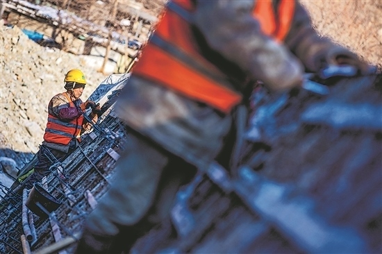 1月3日，房山區(qū)，工人正在雙泉河修筑堤壩。