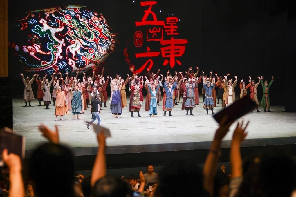 2023年7月31日，新疆和田地區(qū)新玉歌舞團在烏魯木齊京劇院演出舞劇《五星出東方》后和觀眾互相揮手致意。這場演出是第六屆中國新疆國際民族舞蹈節(jié)的參演劇目之一，曾榮獲國家“文華獎”等。新華社記者 郝昭 攝