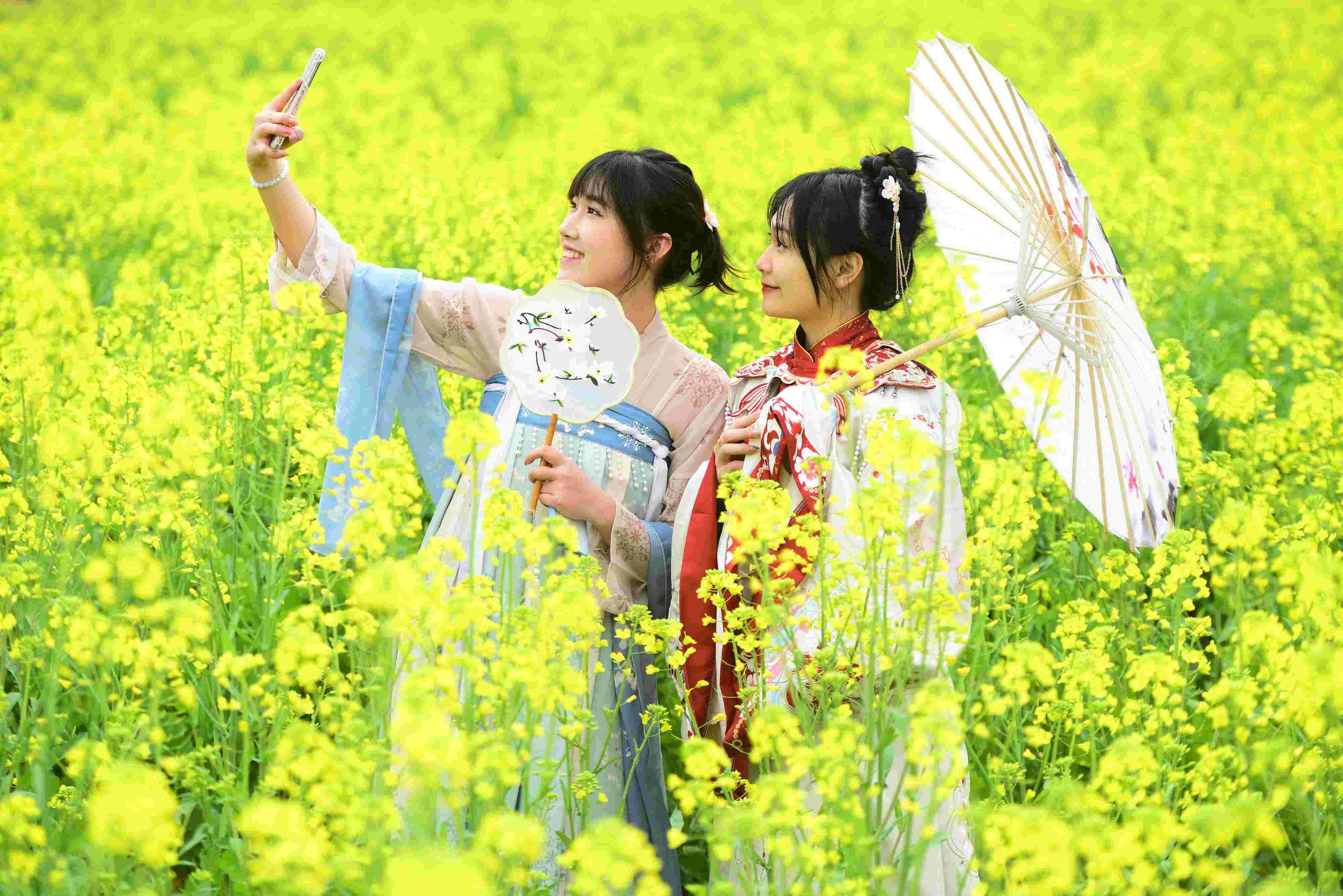 △ 2024年2月16日，廣西賀州，在富川瑤族自治縣麥嶺鎮(zhèn)三民村，游客在油菜花田間賞花拍照。