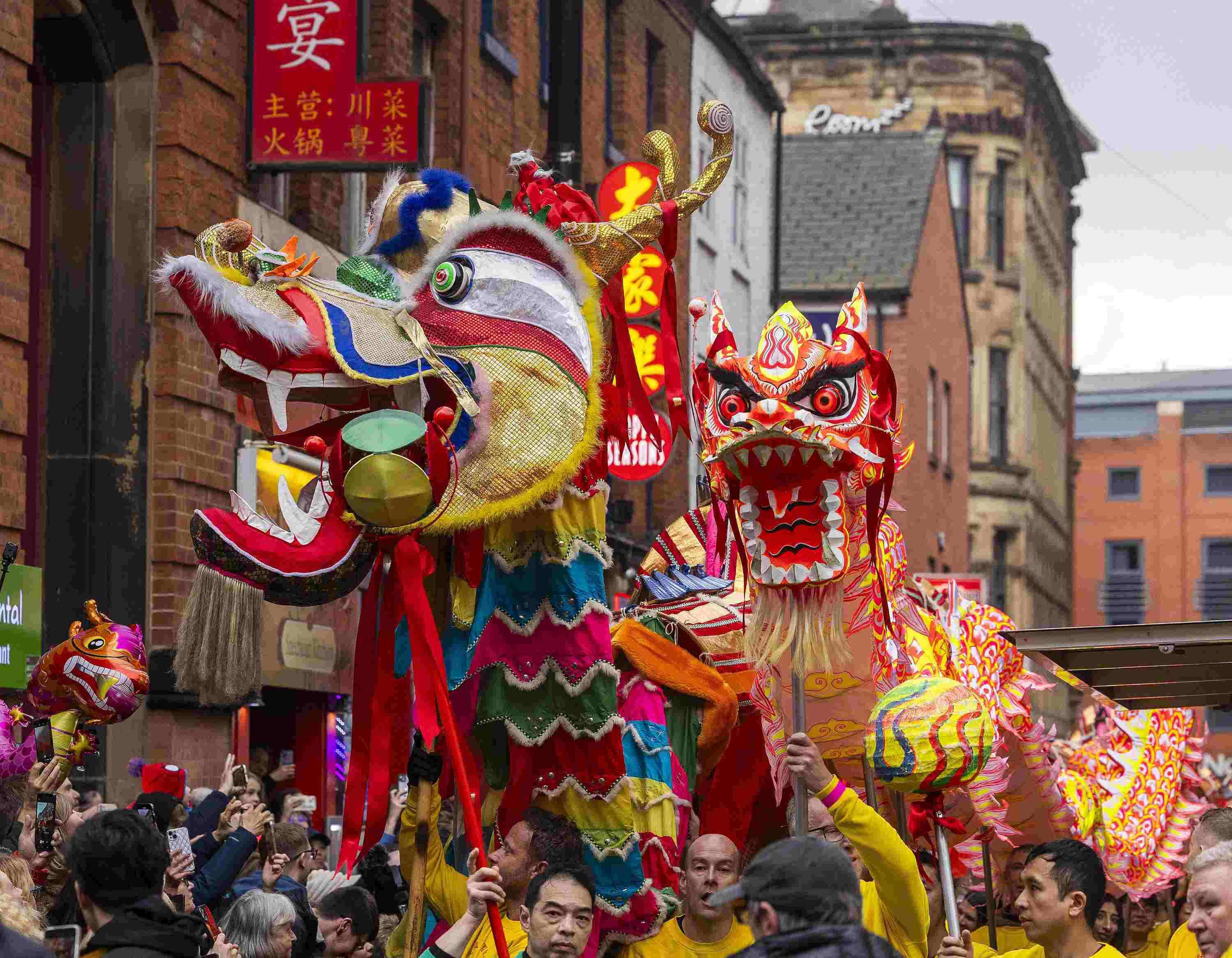 △ 當(dāng)?shù)貢r間2024年2月11日，英國曼徹斯特，表演者進入中國城，參加中國農(nóng)歷龍年春節(jié)的慶?；顒?。