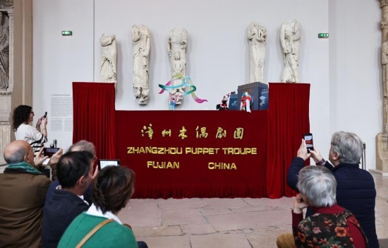 2月10日，在位于法國巴黎埃菲爾鐵塔附近的“建筑與遺產之城”博物館，觀眾欣賞漳州布袋木偶戲。新華社記者高靜攝