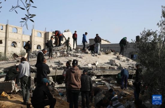  3月3日，在加沙地帶南部城市拉法，人們查看被以軍空襲破壞的建筑。新華社發(fā)（哈立德·奧馬爾攝）