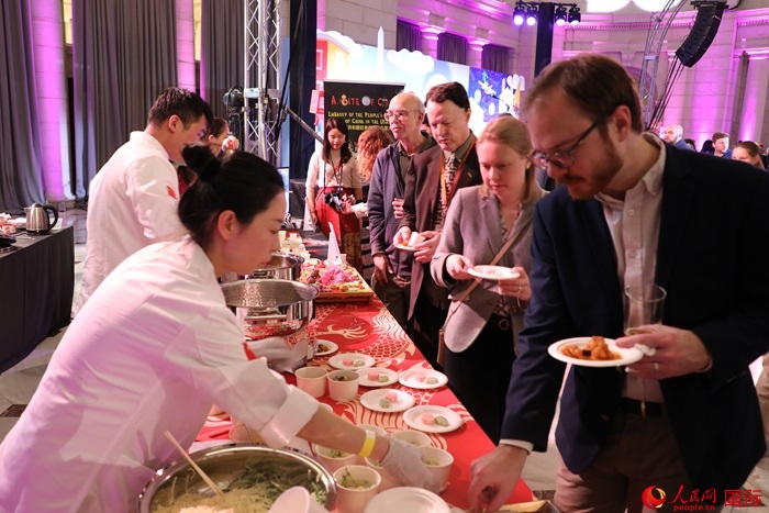 當(dāng)?shù)貢r間3月7日晚，華盛頓聯(lián)合車站廣場舉行駐美使團(tuán)“使館主廚挑戰(zhàn)賽”。圖為當(dāng)?shù)孛癖娫谥袊古_前體驗(yàn)中國美食。人民網(wǎng)記者 李志偉攝